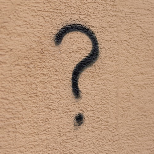 a black question mark written on a wall